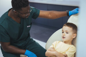 A dental hygienist training grad speaking to a young patient