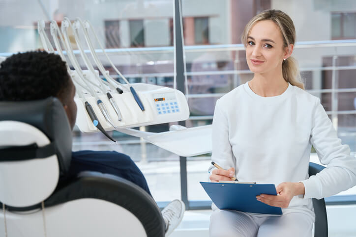 dental assistant school grad helping a patient at chairside