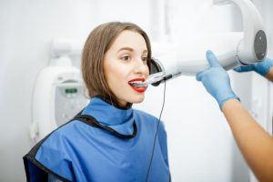 A dental hygienist training grad taking an x-ray image of a patient
