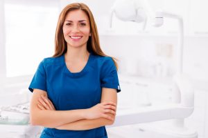 A smiling female dental hygienist at her workplace after completing her dental hygienist program