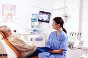 A dental assistant talking to a patient before a procedure
