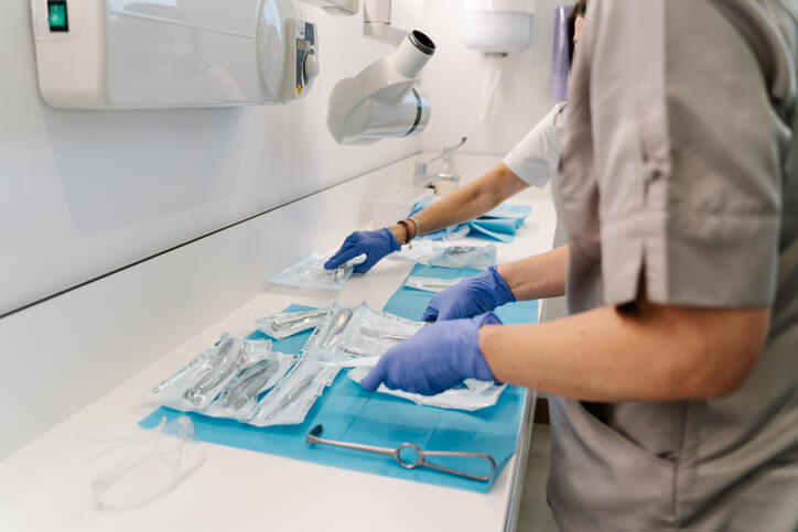 A dental assistant preparing tools in a modern dental office, answering part of the question, What is a dental assistant