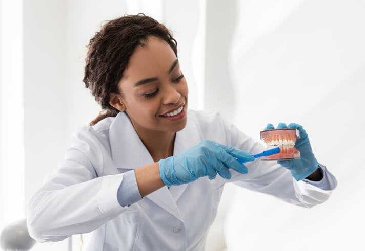 A CADH student practicing dental cleaning techniques