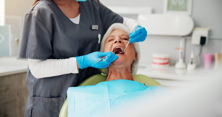 A dental hygienist using a scaler during a cleaning