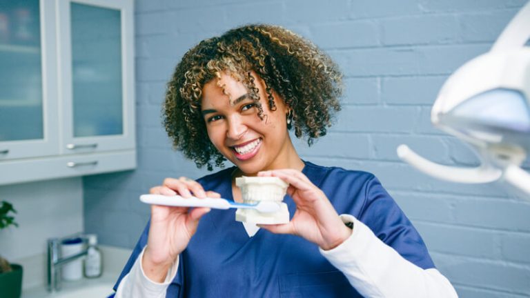 A dental hygiene student practicing teeth cleaning during lab training
