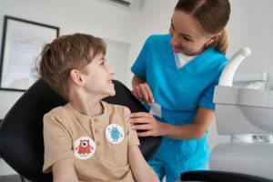 A dental hygiene student with a young client at a student lead dental care clinic offering affordable dental hygiene care.