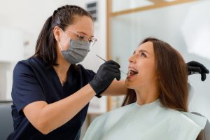 A dental hygienist performing a preventive oral health assessment