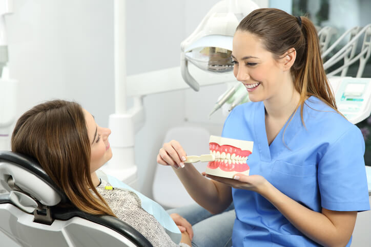 A dental hygienist educating a patient about oral health