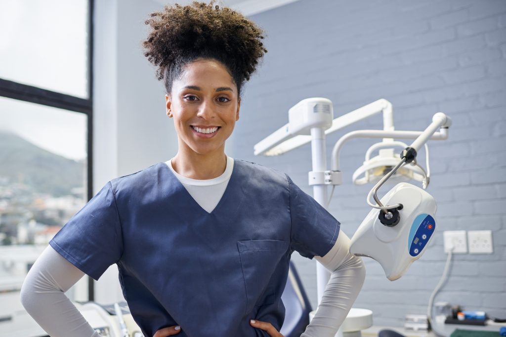 Smiling female dental hygiene professional in a modern clinic setting, representing the rewarding and flexible nature of a dental hygiene career.