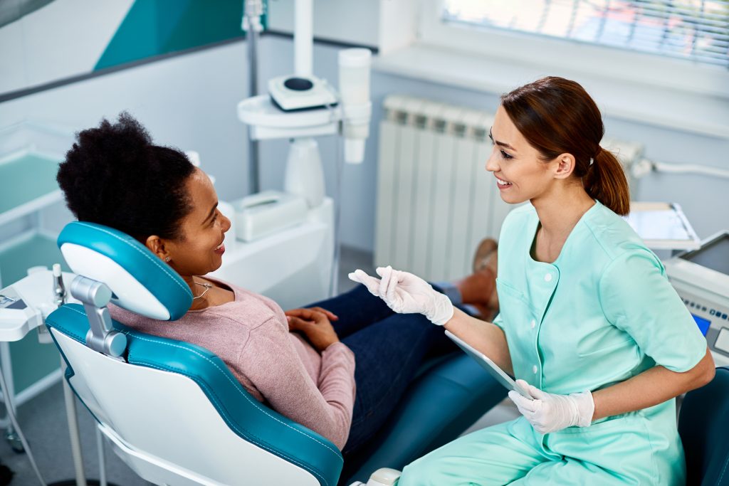 A dental assistant helping a nervous patient feel safe in a dental clinic