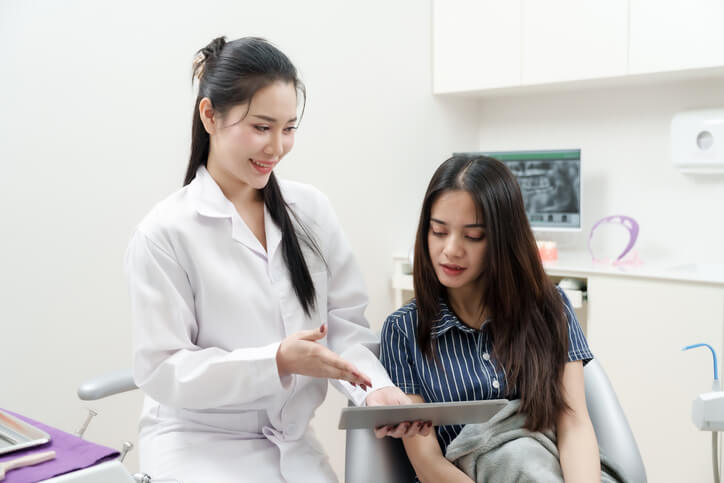 A dental assistant using digital tools and technology in 2026, demonstrating dental assistant skills