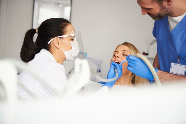 A dental assistant assisting a dentist during an orthodontic procedure