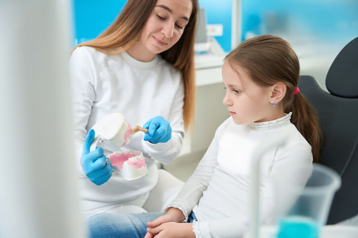 A dental hygienist educating a patient about oral hygiene techniques