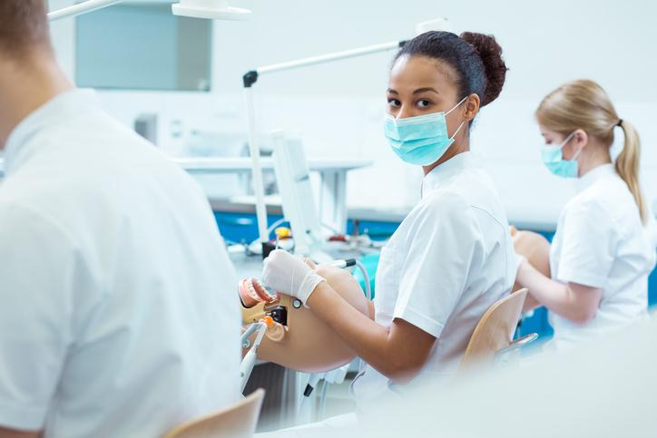 A dental assisting student practising intra-oral skills during clinical training